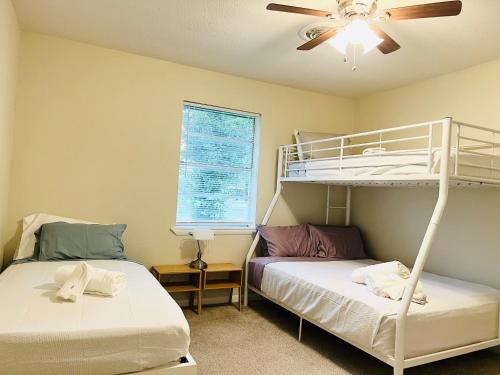 杜兰特The Lil' Yellow Door8的一间卧室设有两张双层床和吊扇