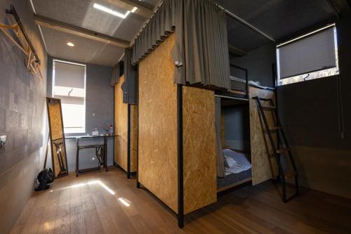 增田ゲストハウス＆カフェ　ハレテル的客房设有三张双层床和一张桌子。