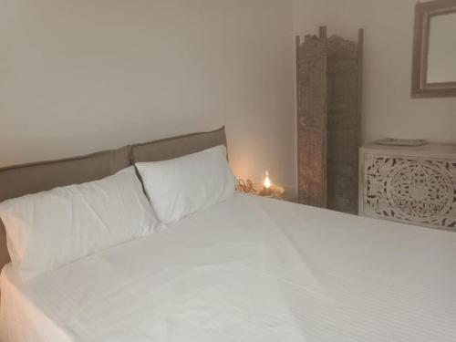圣托斯特凡诺港Luxury beach house的一间卧室配有一张带白色床单和一盏灯的床。