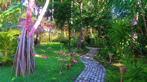 吉利阿尔UTOPIA的花园中种有树木和鲜花的鹅卵石路径
