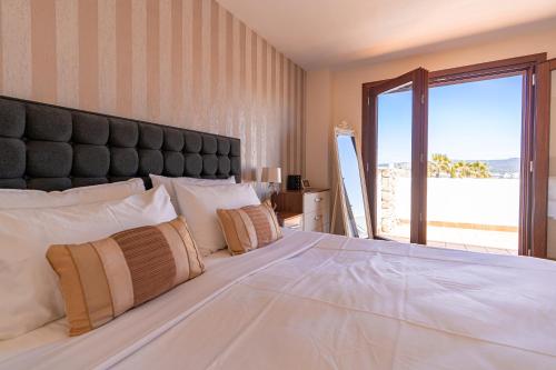 圣何塞德萨塔莱阿Beautiful Villa Bohemia Ibiza的卧室设有一张大白色的床和大窗户