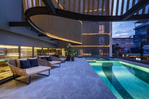 曼谷贝斯特韦斯特拉查达酒店的一座带躺椅的游泳池和一座建筑