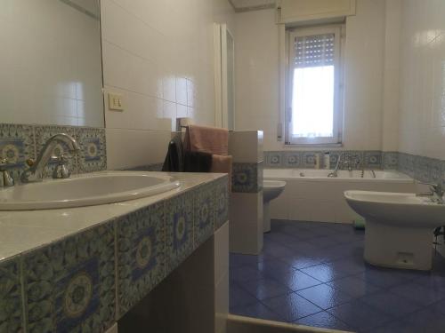 萨莱诺Nel Giardino Fiorito的一间带两个盥洗盆、浴缸和卫生间的浴室