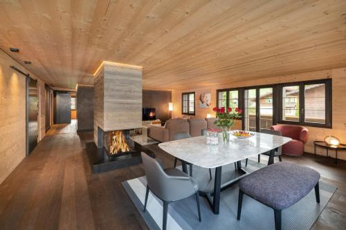 格施塔德Swiss Hotel Apartments - Gstaad的客厅配有桌子和壁炉