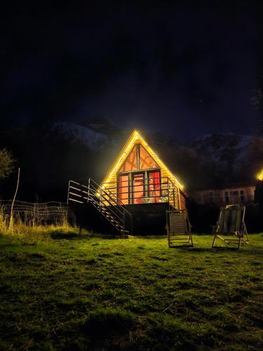 卡兹贝吉Kazbegi Kuro Cottages的夜间有灯的小屋