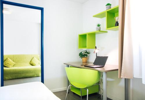 马赛Twenty Business Flats Marseille Timone的一间卧室配有一张桌子、一台笔记本电脑和一张绿色椅子