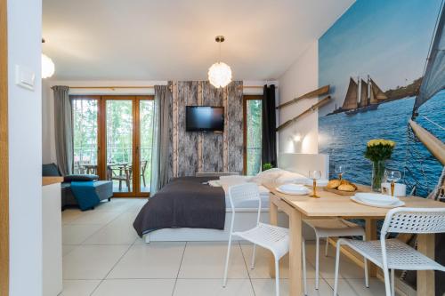 斯蒂格纳Apartamenty NCNK Baltic Park w Stegnie - 500 m do plaży的卧室配有一张床和一张桌子及椅子