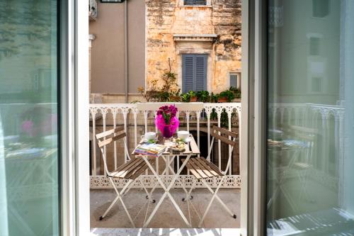 特拉尼Le Marinelle Trani B&B的阳台上的一张带鲜花的桌子