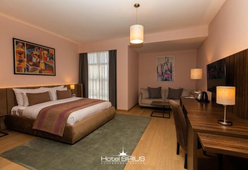 普里什蒂纳天狼星酒店 的一间卧室配有一张床、一张桌子和一张沙发