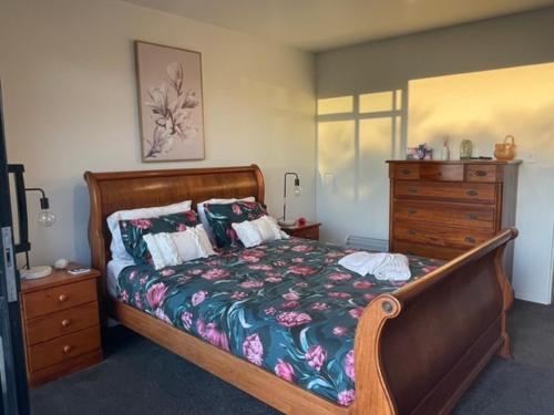 WaikawaMoana BnB, Waikawa Bay, Picton的一间卧室配有木床和梳妆台