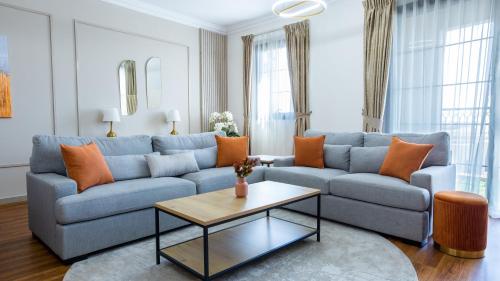 迪拜GOODWOOD SUITES HOMES VACATION的客厅配有蓝色的沙发和桌子