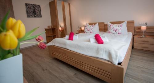 梅塞尼希Weingut Erich Serwazi的卧室配有一张带粉红色枕头的大床
