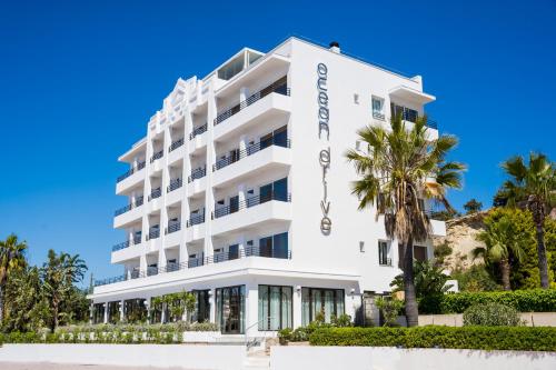 伊维萨镇Ocean Drive Ibiza的一座白色的建筑,前面有棕榈树