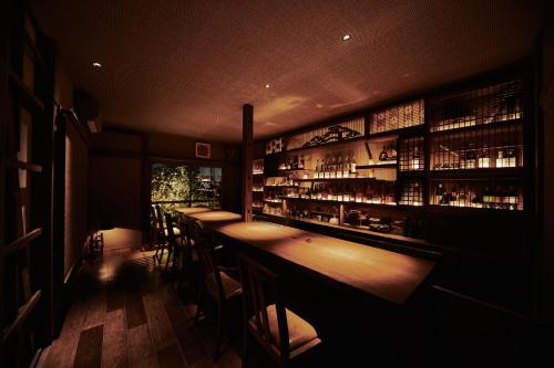 东京Kagurazaka Retro BAR & HOTEL的一间酒吧,房间里有一排酒吧凳