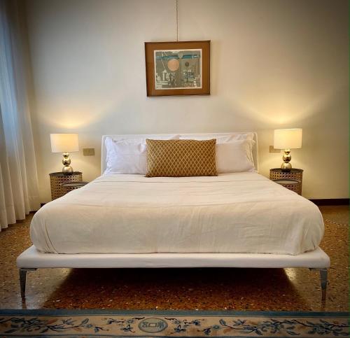 威尼斯Giudecca Palanca 664的卧室内的一张带白色床单和枕头的床