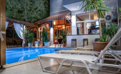 尼亚普拉莫斯吉普斯度假酒店的房屋旁带躺椅的游泳池