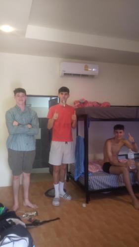 Ban NuaBoy Scouts Homestay的三位男子站在一个配有双层床的房间