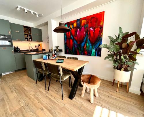 赫鲁德B&B Logement 't Slikje的厨房以及带桌子和绘画的用餐室