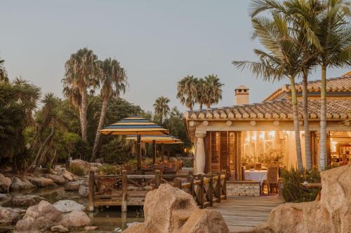 维拉Desert Springs Resort的一座带遮阳伞的木甲板的房子