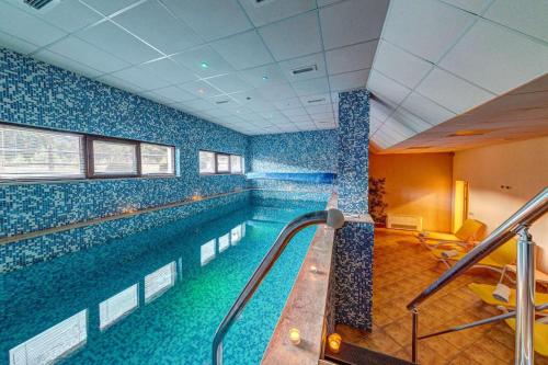 斯莫梁Black Box Studio的蓝色瓷砖建筑中的一个大型游泳池