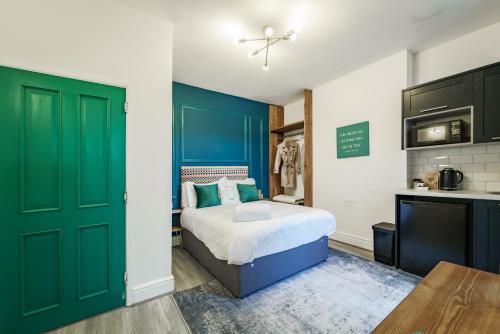 埃文河畔斯特拉特福Emerald Stays UK at The Adelphi的一间卧室设有一张带绿门的床和一间厨房