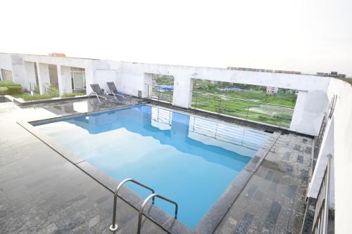 加尔各答The Xen Suites, Kolkata Airport的大楼内的一个蓝色海水游泳池