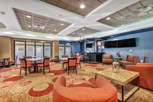罗利温盖特温德姆国家体育场罗利/卡里酒店的大堂设有桌椅和酒吧。