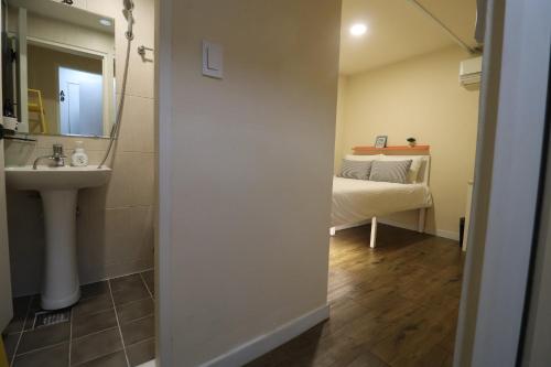 首尔只为你旅舍的一间带水槽和镜子的浴室以及一张床