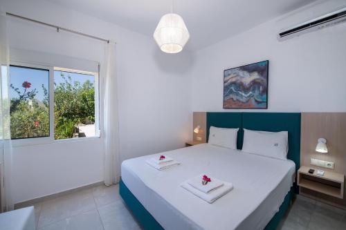 埃拉福尼西岛Elafonisi Village的卧室配有白色床和2条白色毛巾
