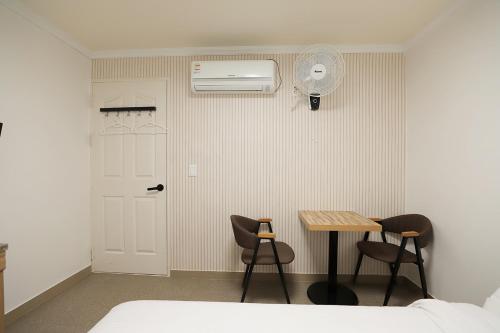 庆州Stay RomanticTrip_Hostel的一间卧室配有桌椅和风扇