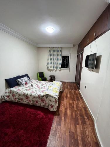 卡萨布兰卡Résidence Faouazi的一间卧室配有一张床和红色地毯