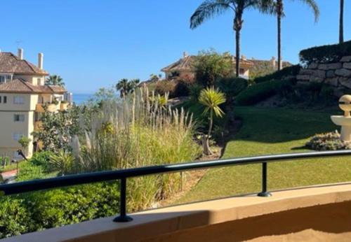 马贝拉New refurnished Apartment Elviria Hills Marbella的阳台享有棕榈树庭院的景致。
