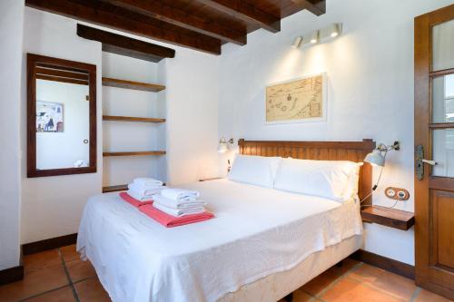 蒂亚斯Casa Amaia II的卧室配有白色床和毛巾
