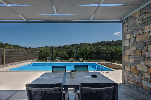 圣特里亚斯Kalostous的一个带桌椅的庭院和一个游泳池