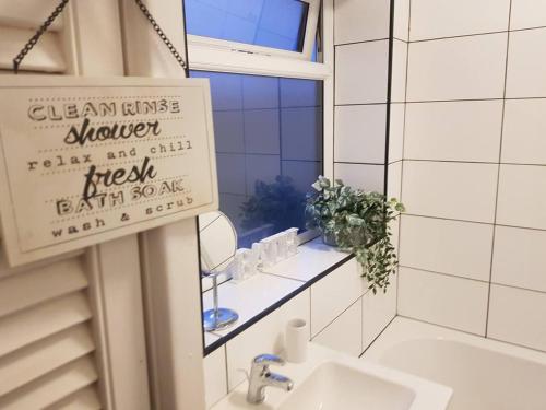 曼彻斯特Bright 4-Bed house 15 min to Manchester Centre的一间带水槽和镜子的浴室以及窗户。