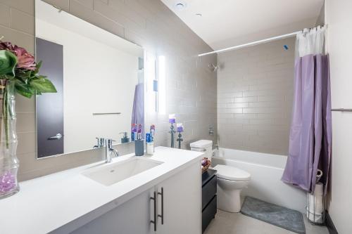 汉密尔顿GLOBALSTAY New Downtown Hamilton Apartments的一间带水槽、卫生间和镜子的浴室