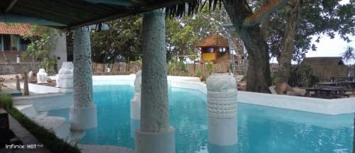 卡里塔Noah's Beach Condo at Lippo Carita Utara的度假村内带柱子的游泳池