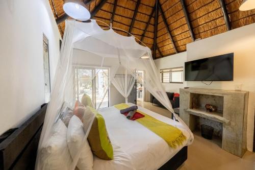 玛洛斯帕克African Sky Villas的一间卧室配有一张带蚊帐的床