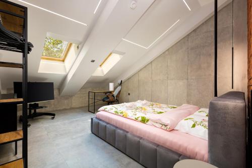 普罗夫迪夫Industrial-style 2BD Loft with Parking Spot的阁楼卧室配有床和电视。