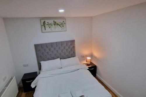 埃尔特姆1 Bedroom Studio的卧室配有白色床和银色床头板