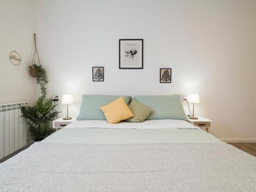 钱皮诺Casa Design Con A/C e WiFi_[7 MINUTI CIAMPINO AEROPORTO]的一间卧室配有一张带两盏灯的大型白色床。