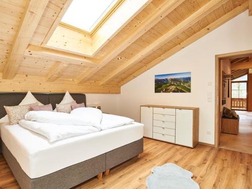 柯尼希斯湖畔舍瑙Krennlehen的一间带一张大床的卧室,位于一个拥有木制天花板的房间