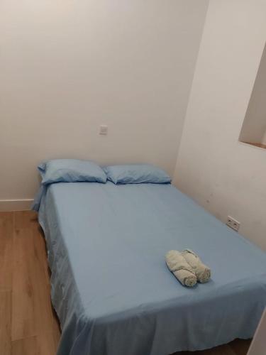 马德里Habitación en Madrid的一张带蓝色床单和蓝色枕头的床