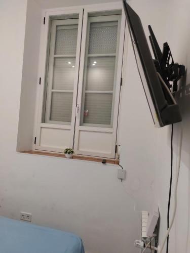 马德里Habitación en Madrid的一间带电视的白色客房的窗户