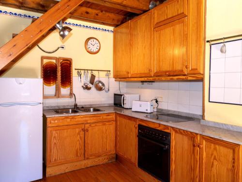 普拉德埃米塔Apartment Herbasabina by Interhome的厨房配有木制橱柜和白色冰箱。