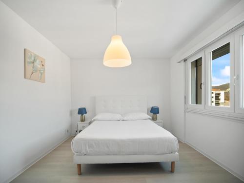 卡斯拉诺Caslano City Apartments的白色的卧室设有白色的床和窗户。