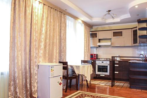 阿拉木图Tolebaeva 65的厨房以及带桌子和窗帘的用餐室