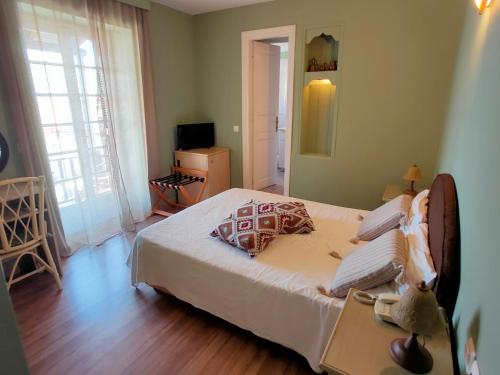 阿吉奥斯伊欧尼斯Galini Hotel Agios Ioannis Pelion的一间卧室配有一张床和一台电视