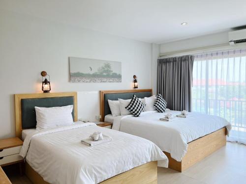 乌隆他尼普坎宁酒店的一间卧室设有两张床和窗户。