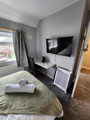 伯明翰Fox Hollies Shared House的酒店客房设有一张床、一张书桌和一台电视机。